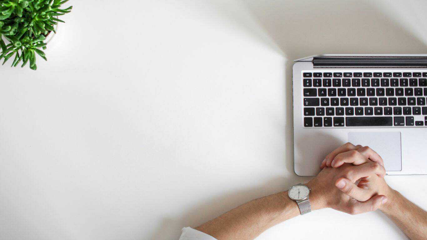 person wearing watch near laptop